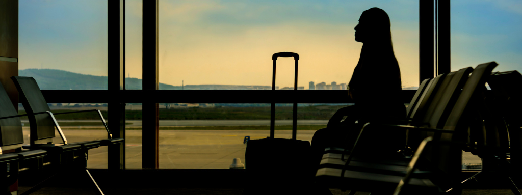 woman sitting at airport with luggage