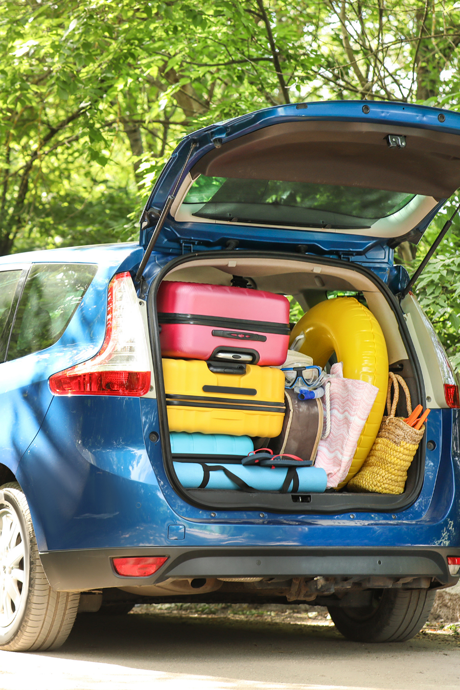 car boot packed with colourful suitcases 