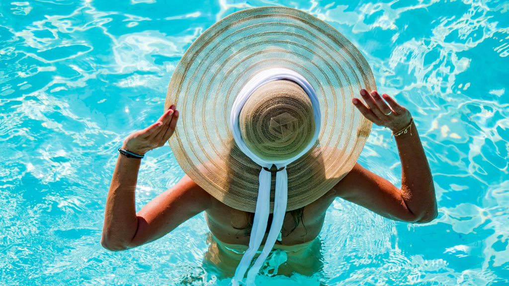 woman in pool wearing large sun hat