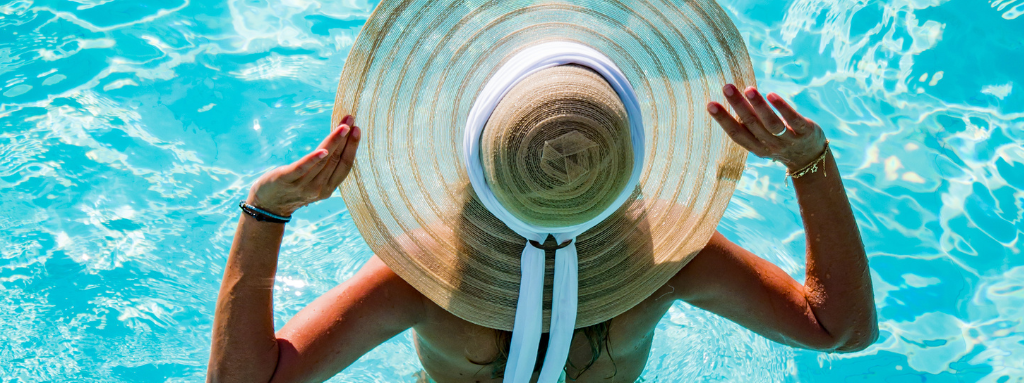 woman in pool wearing large sun hat